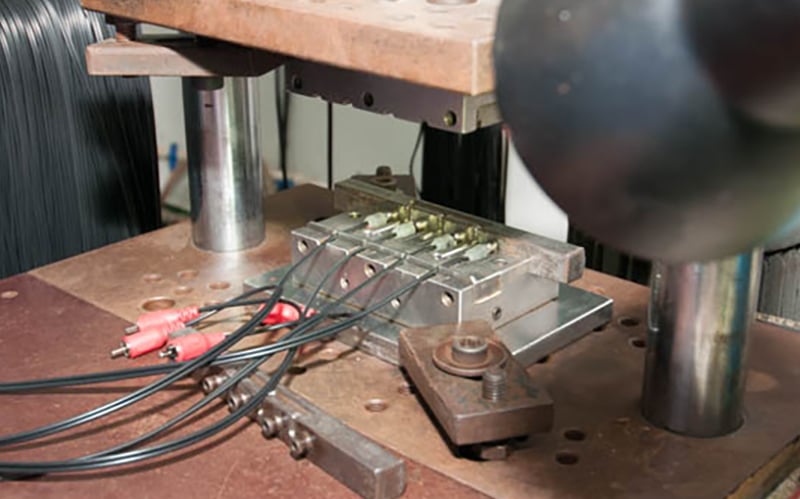 Overmolded cables being manufactured